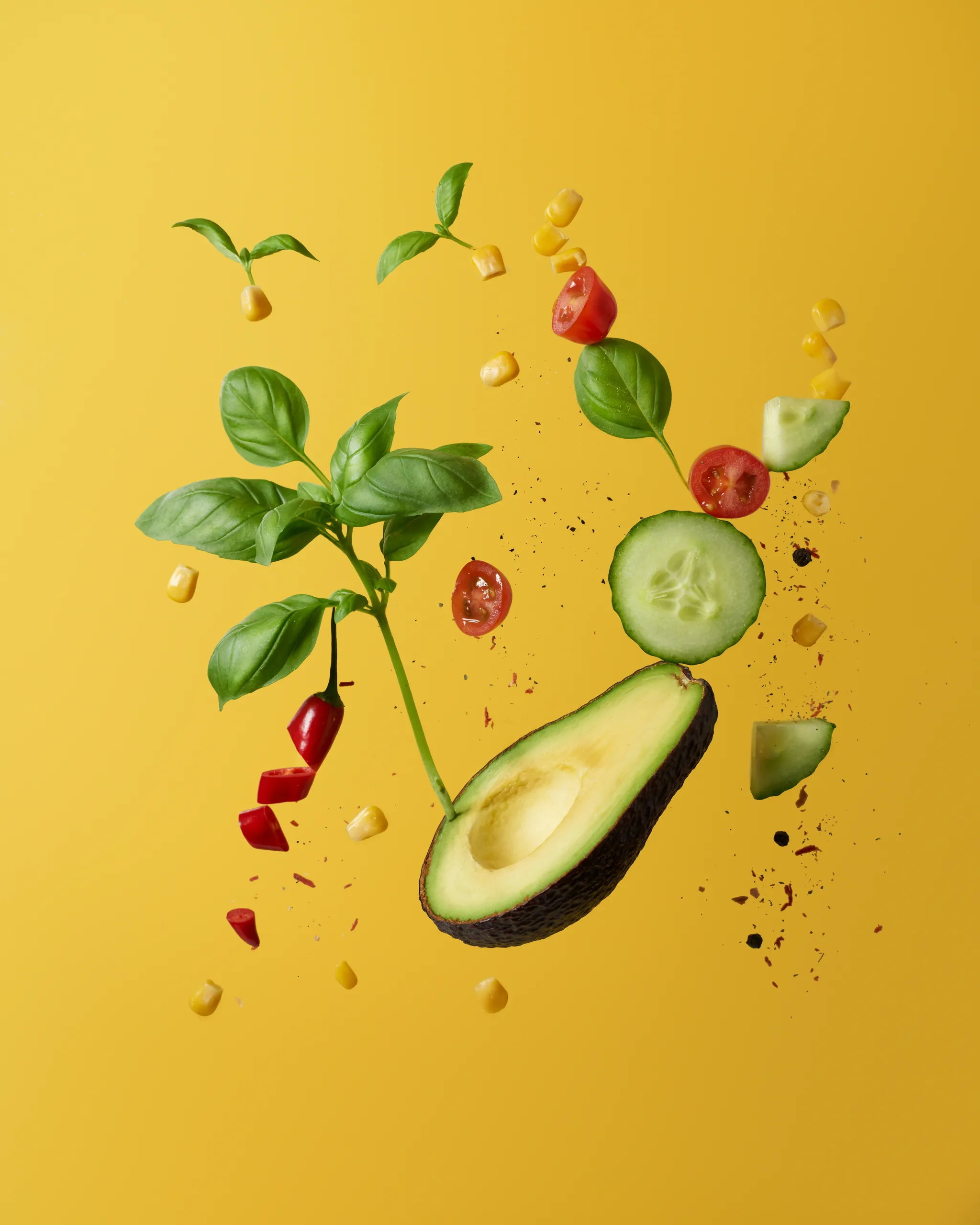 Verduras frescas y aguacate en el aire sobre fondo amarillo